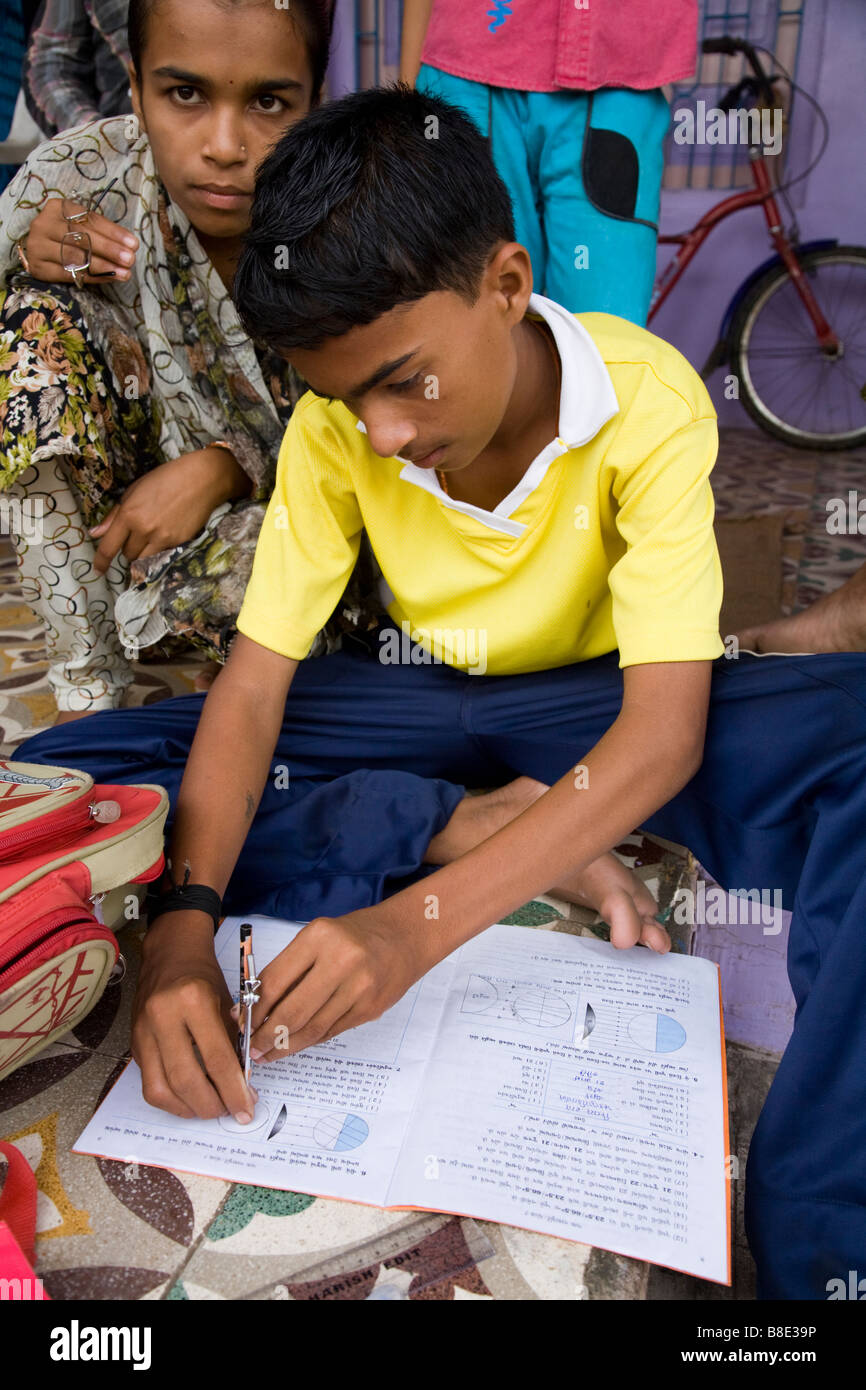 Faire ses devoirs d'écolier de l'école dans son livre d'exercice. Hazira, Surat, Gujarat. L'Inde Banque D'Images