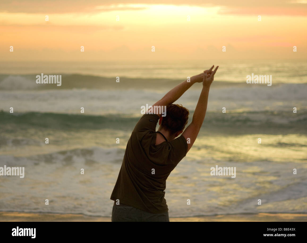 Une femme n'yoga sur une plage à l'aube. Banque D'Images