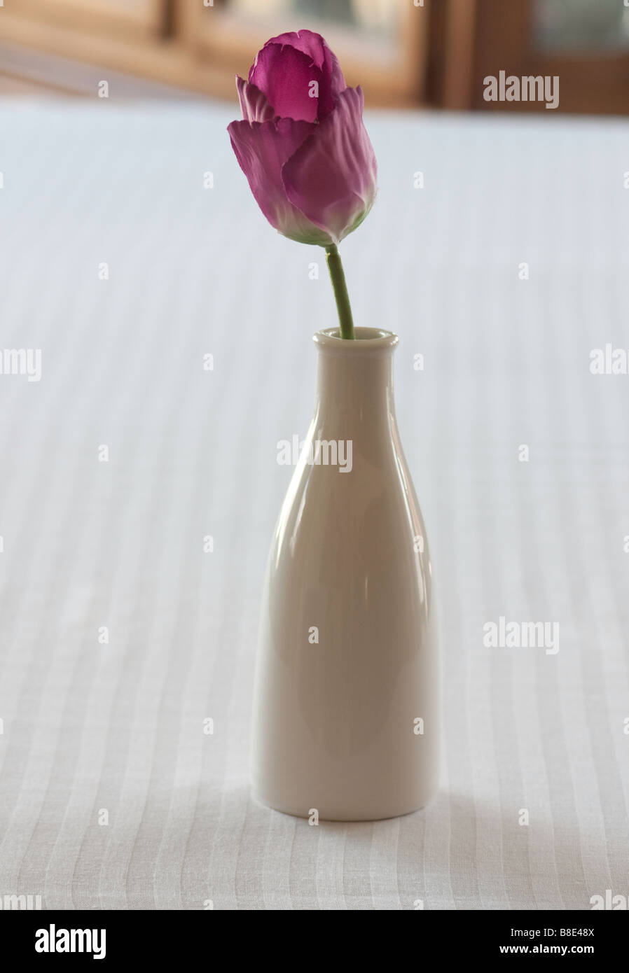 Une tulipe artificielle dans un vase blanc Banque D'Images