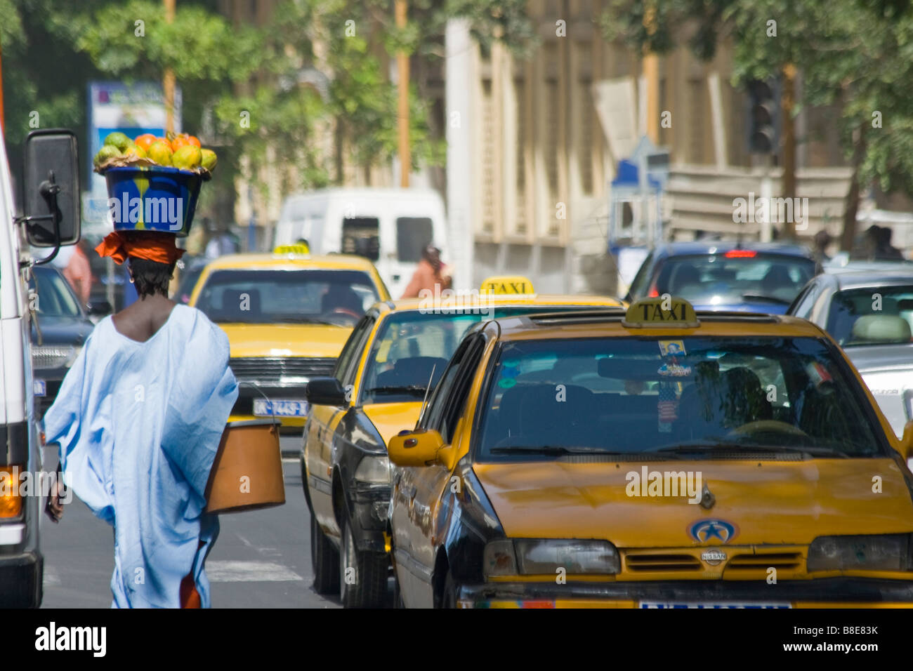 Femme transportant les papayes sur sa tête dans les rues de Dakar Sénégal Banque D'Images