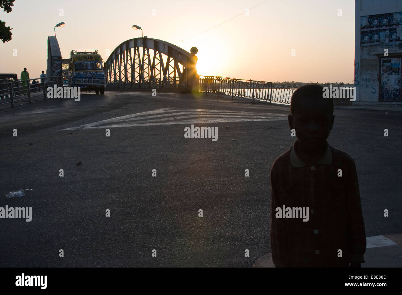 Garçon sans-abri en face du pont Faidherbe à Saint-Louis au Sénégal en Afrique de l'Ouest Banque D'Images