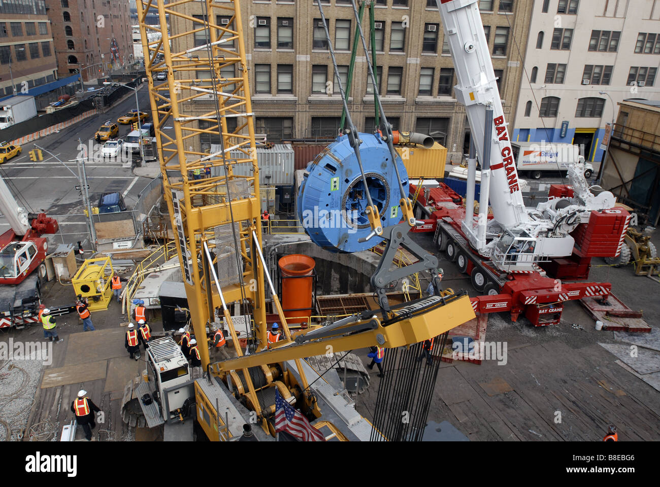 Les travailleurs de la construction se préparer pour abaisser la tête de coupe de 100 tonnes d'un tunnelier en bas d'un arbre dans une chambre d'assemblée Banque D'Images