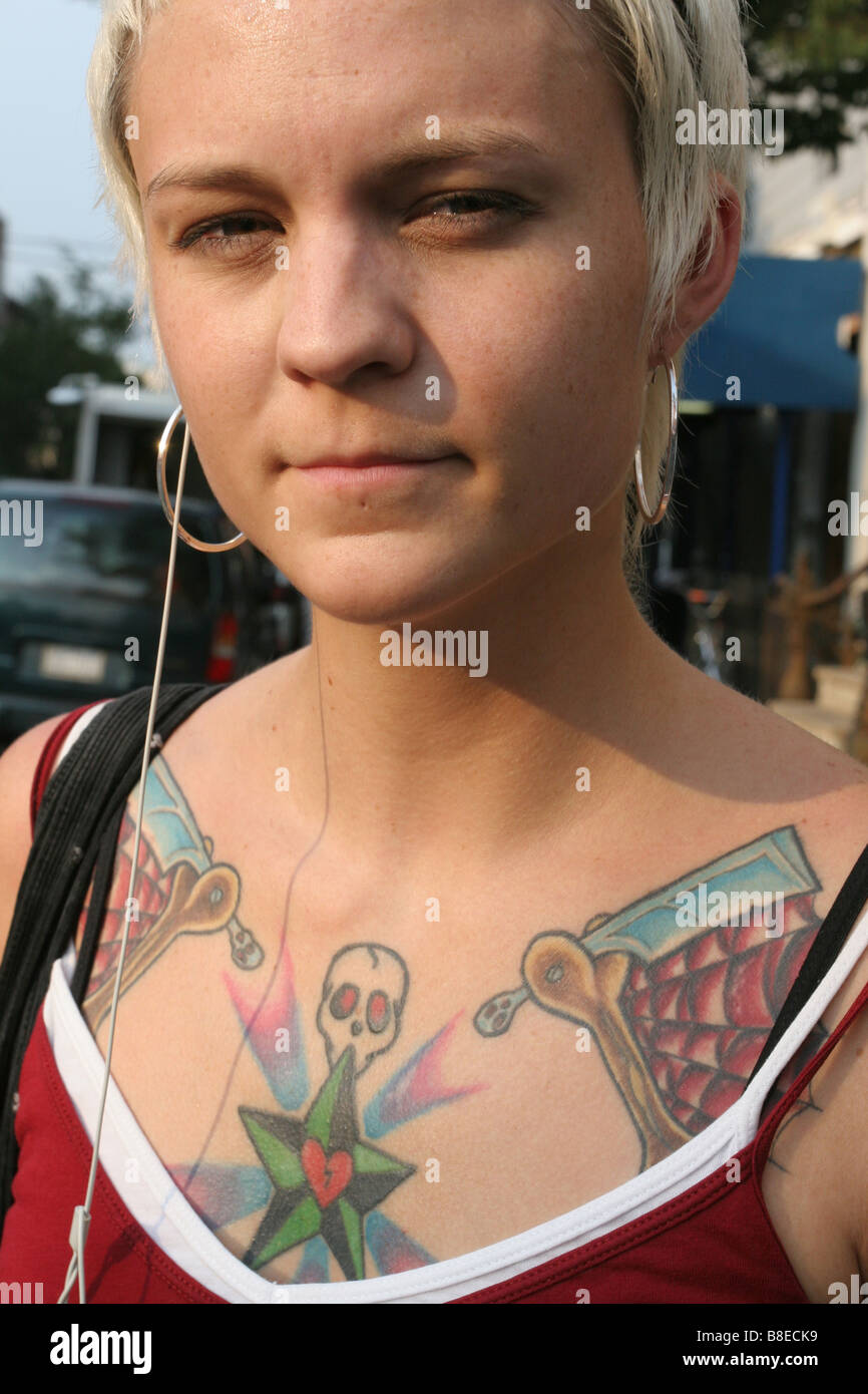 Une jeune femme avec des tatouages graphique en attente d'un bus à New York Banque D'Images