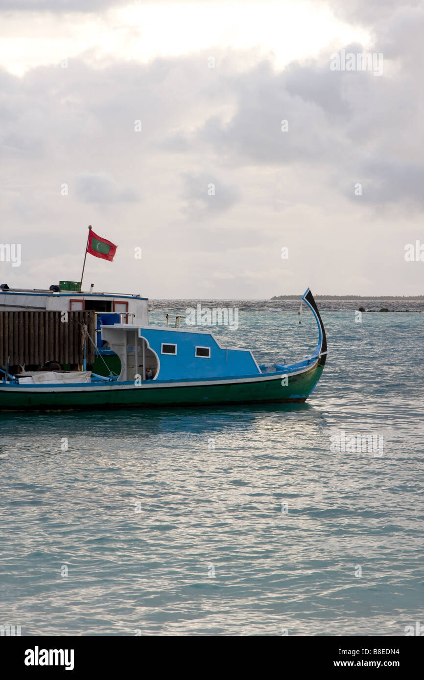 Jour nuageux sur les Maldives. Bateau traditionnel maldivien avec drapeau. Banque D'Images