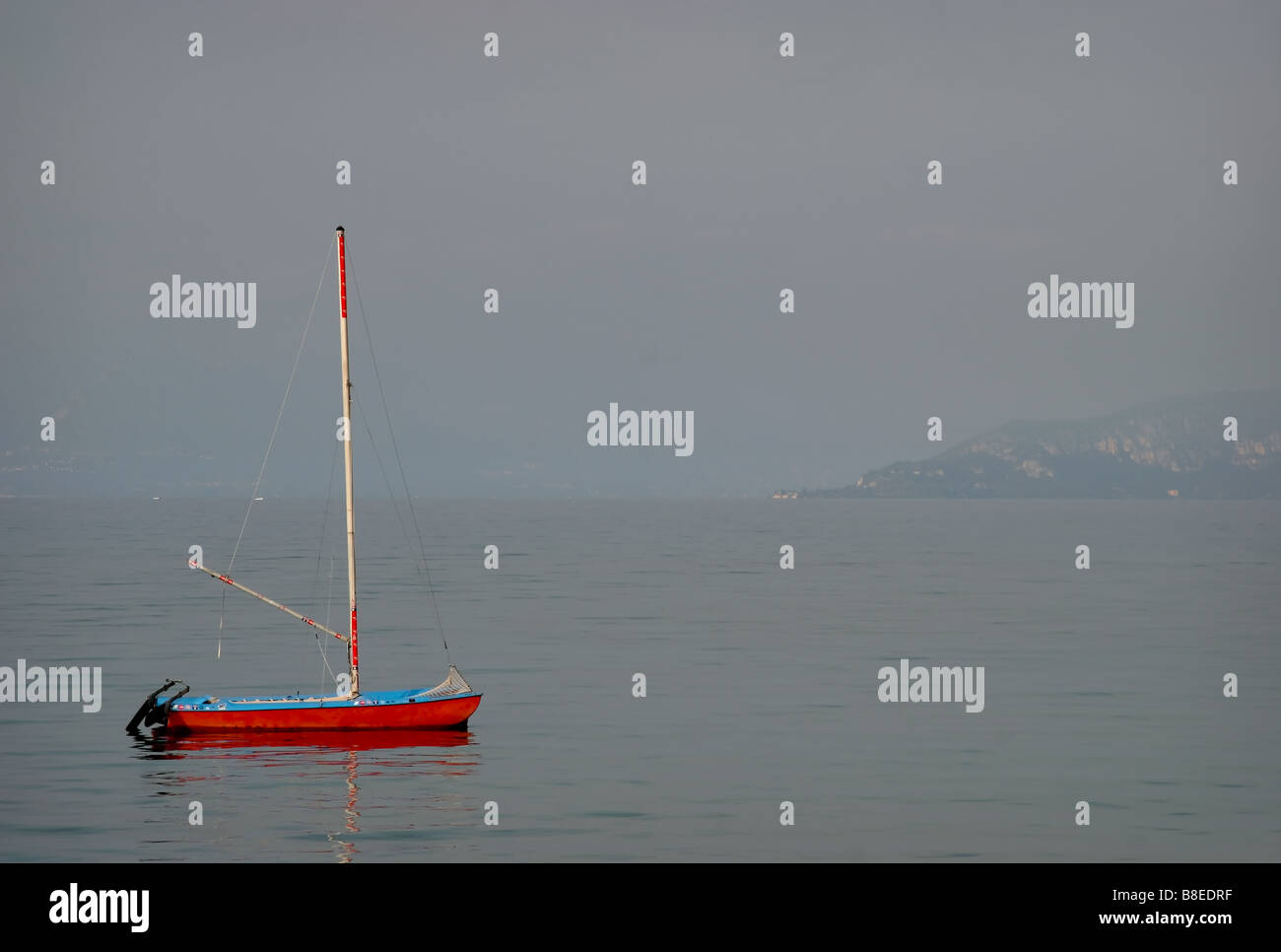 Yacht rouge et brumeux matin sur le lac de Garde Italie Banque D'Images