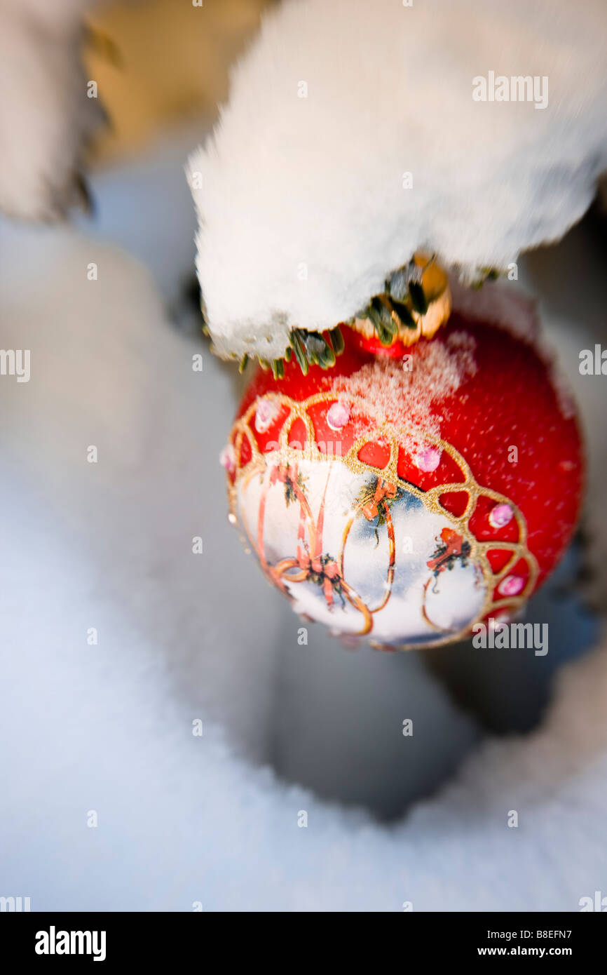 Close up of a Christmas ornament hanging sur une branche en plein air au cours de l'hiver neige Banque D'Images
