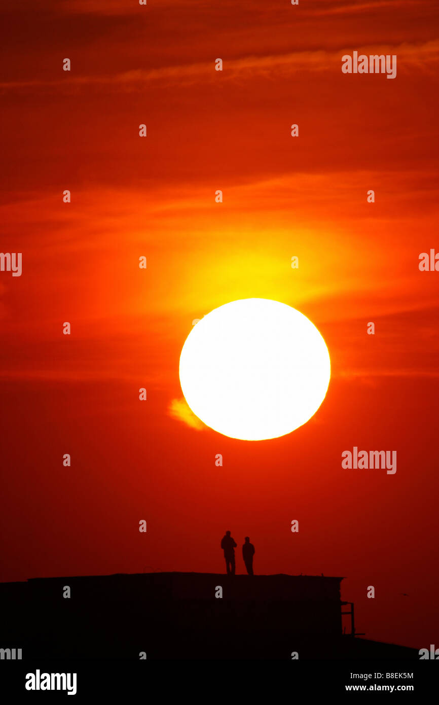 Silhouettes de gens au coucher du soleil Banque D'Images