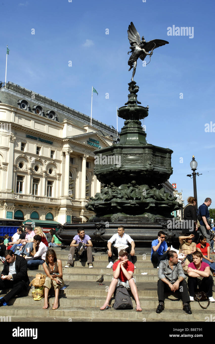 Les touristes assis sur les marches autour de la statue de bronze de l'Éros, Piccadilly Cicus, Londres, Angleterre. Monument érigé en 1893 Banque D'Images