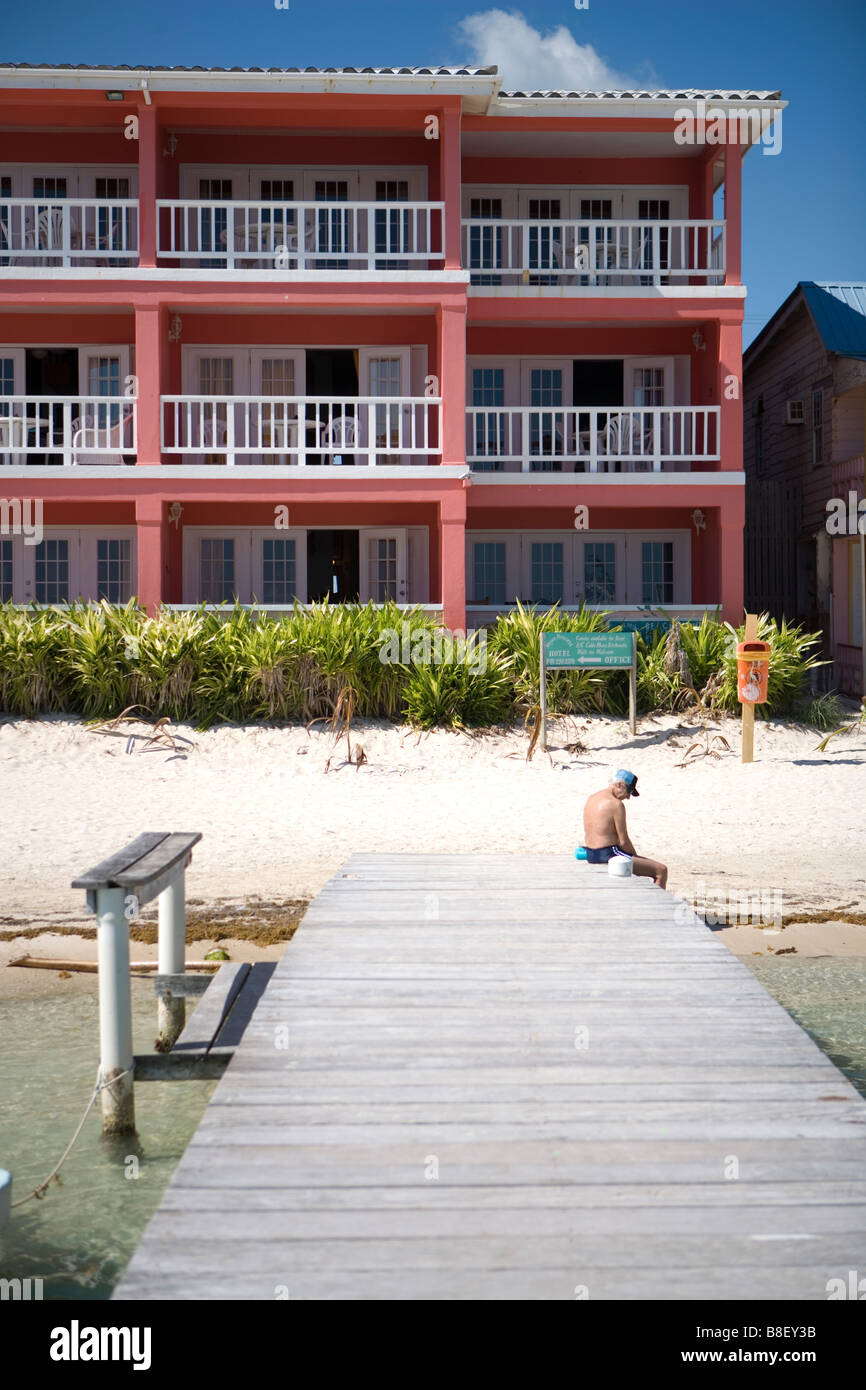 Un seul homme plus âgé est assis à l'extrémité d'une jetée à San Pedro sur Ambergris Caye, Belize. Banque D'Images