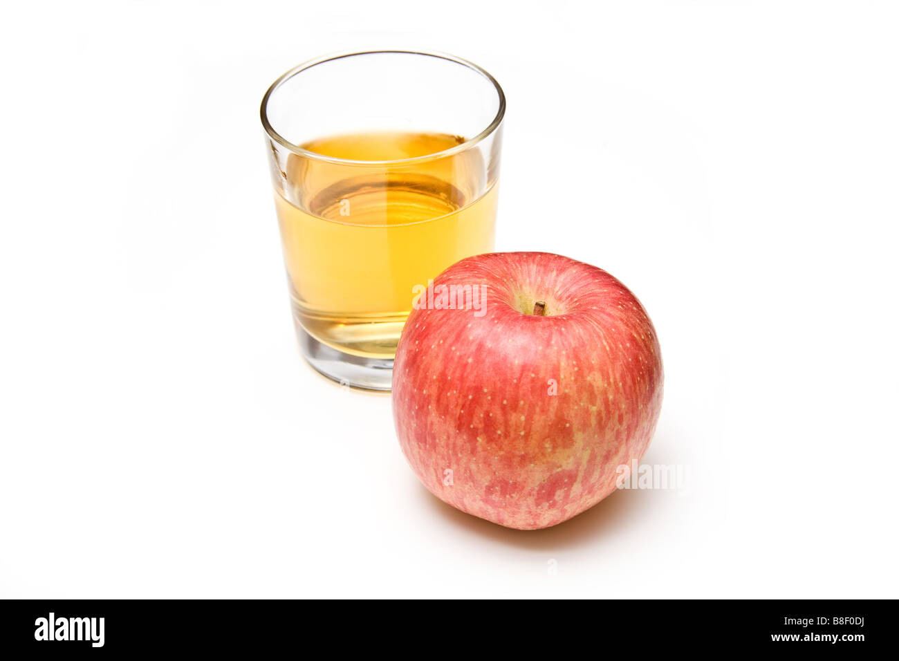 Verre de jus de pomme avec un fuji apple isolated on a white background studio Banque D'Images