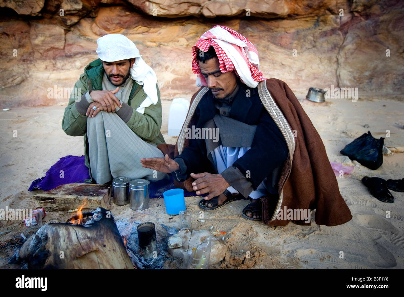 Deux hommes bédouins se réchauffer à un feu de camp en Egypte Banque D'Images