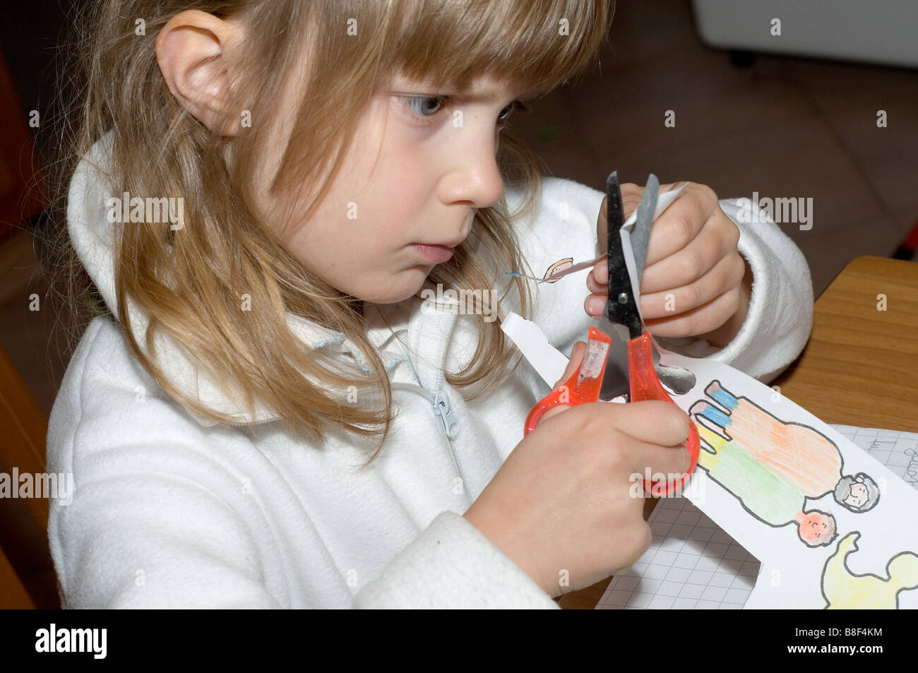une jeune fille s'est occupée à découper des chiffres en papier Banque D'Images