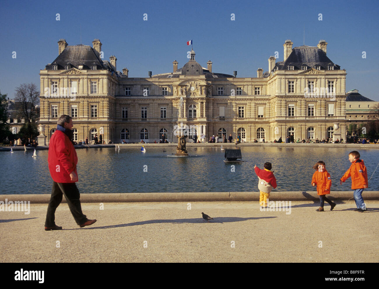 Enfants jouant au lac octogonale dans le jardin du Luxembourg Palais du Luxembourg avec siège du Sénat français à Paris France dist Banque D'Images