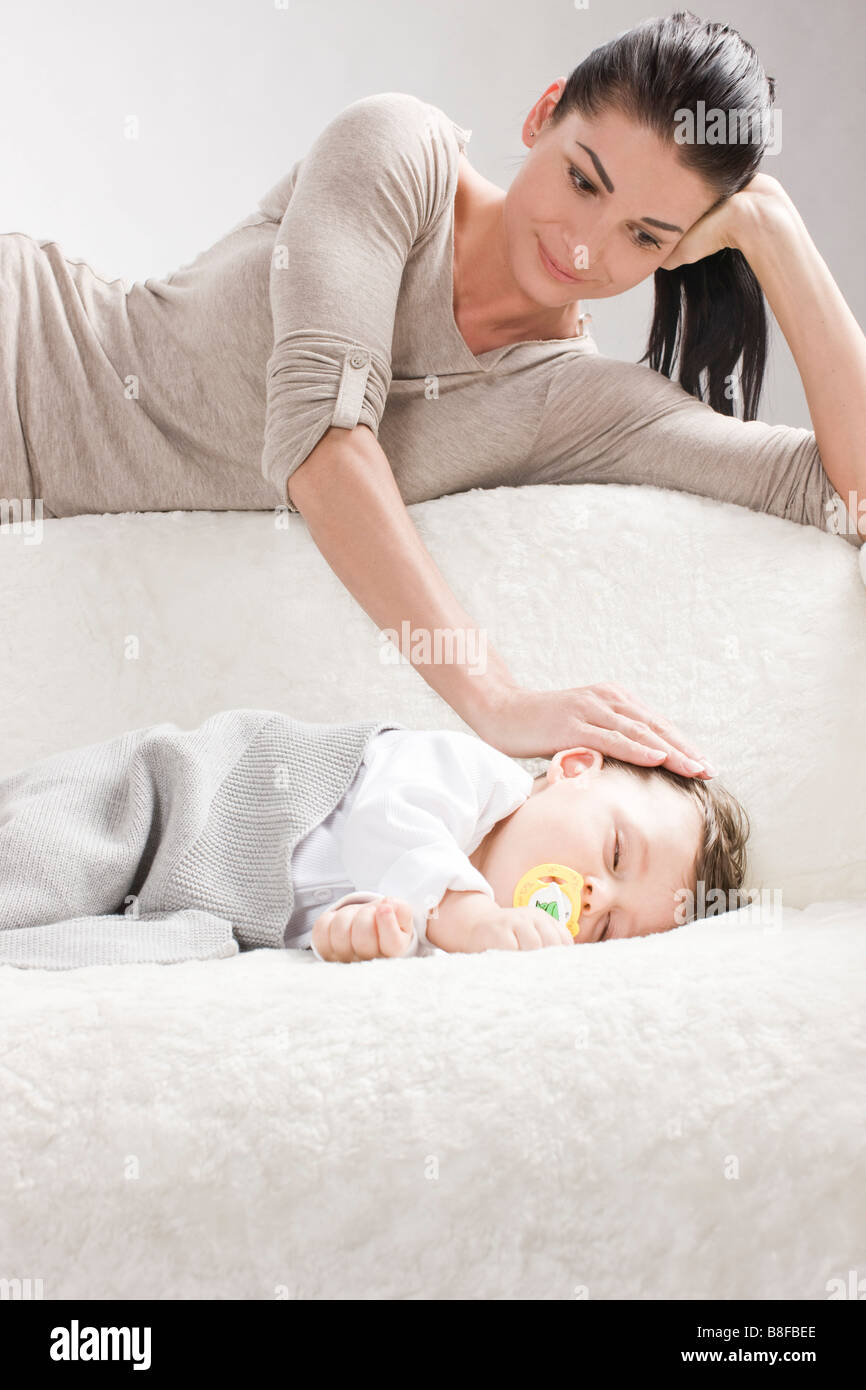 Mère regardant bébé dormir Banque D'Images