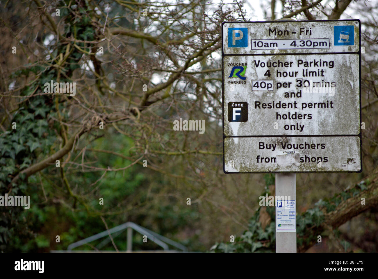 Très sale street sign donnant des détails sur les restrictions de stationnement, dans le London Borough of Richmond upon Thames, Surrey, Angleterre Banque D'Images