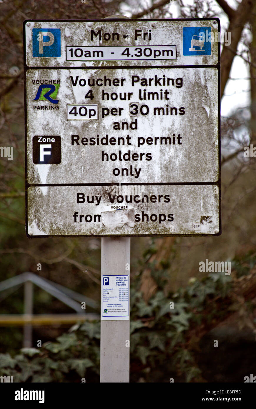 Très sale street sign donnant des détails sur les restrictions de stationnement, dans le London Borough of Richmond upon Thames, Surrey, Angleterre Banque D'Images