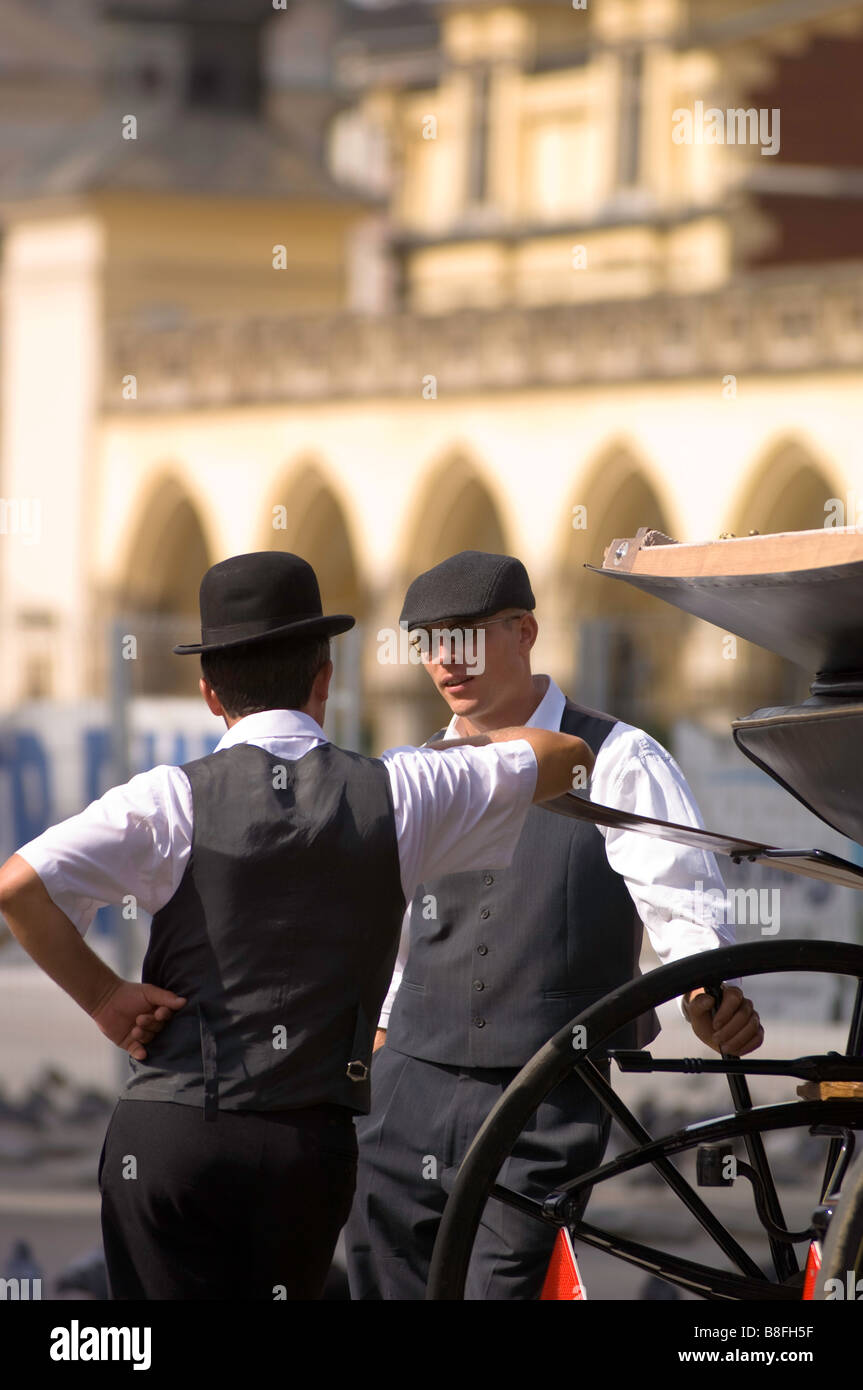 Pologne Cracovie calèches sur Rynek Glowny cochers chatting lors du freinage Banque D'Images
