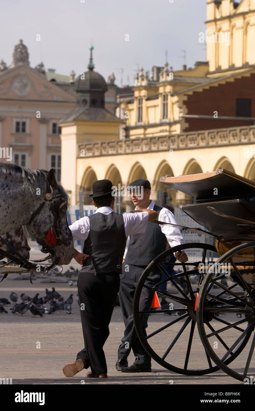 Pologne Cracovie calèches sur Rynek Glowny cochers chatting lors du freinage Banque D'Images