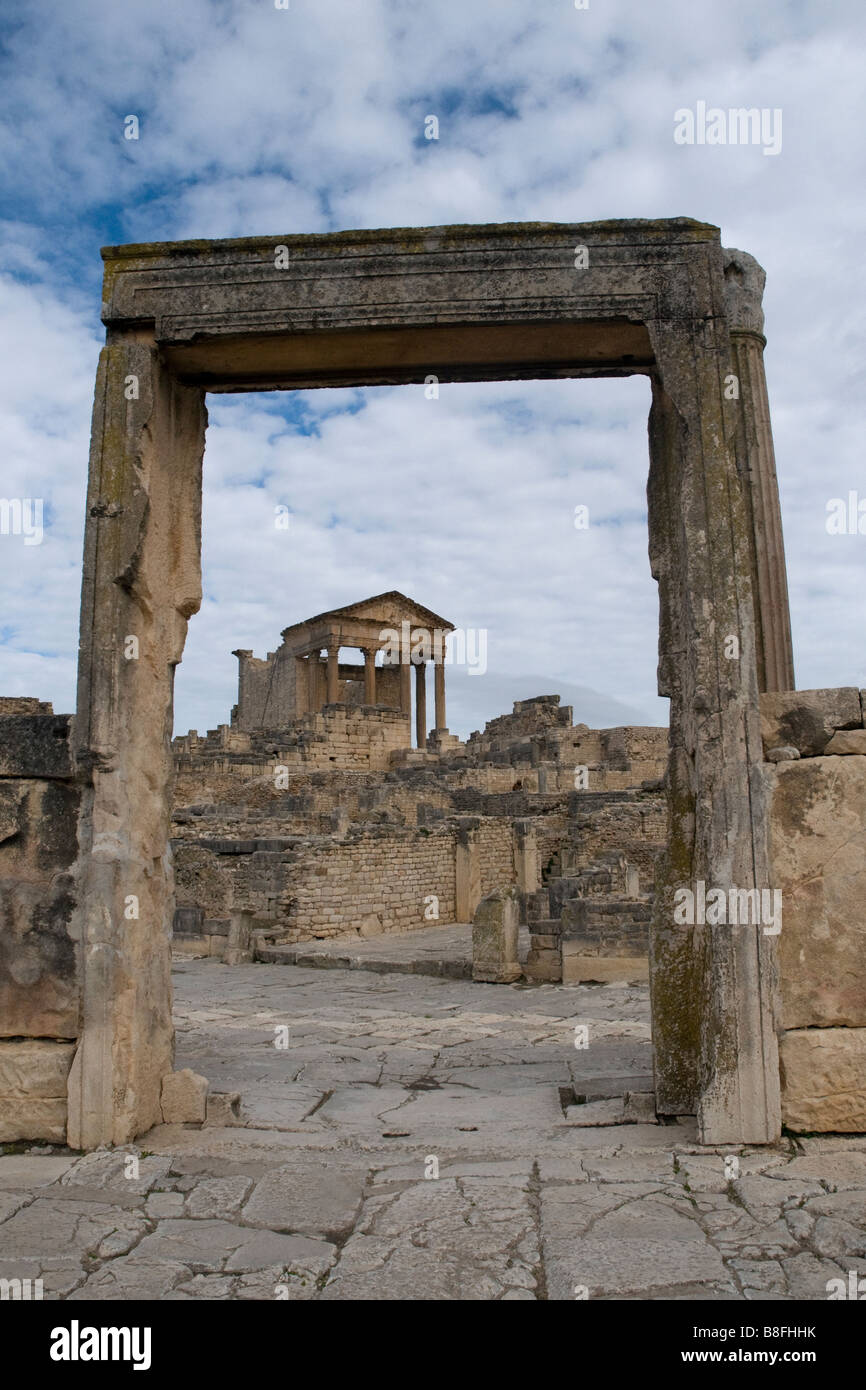 Le Capitole, un premier aspect de la ville romaine de Dougga, vue à travers une arche en bas de la colline Banque D'Images