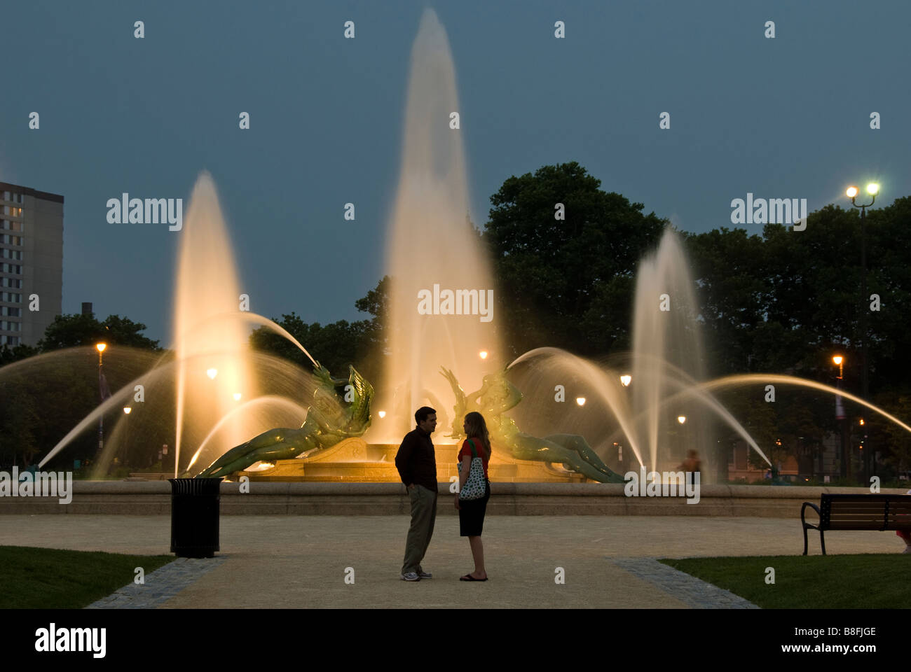 Couple stand en face de Swann Memorial Fountain au crépuscule, Logan Square, Philadelphie, Pennsylvanie. Banque D'Images