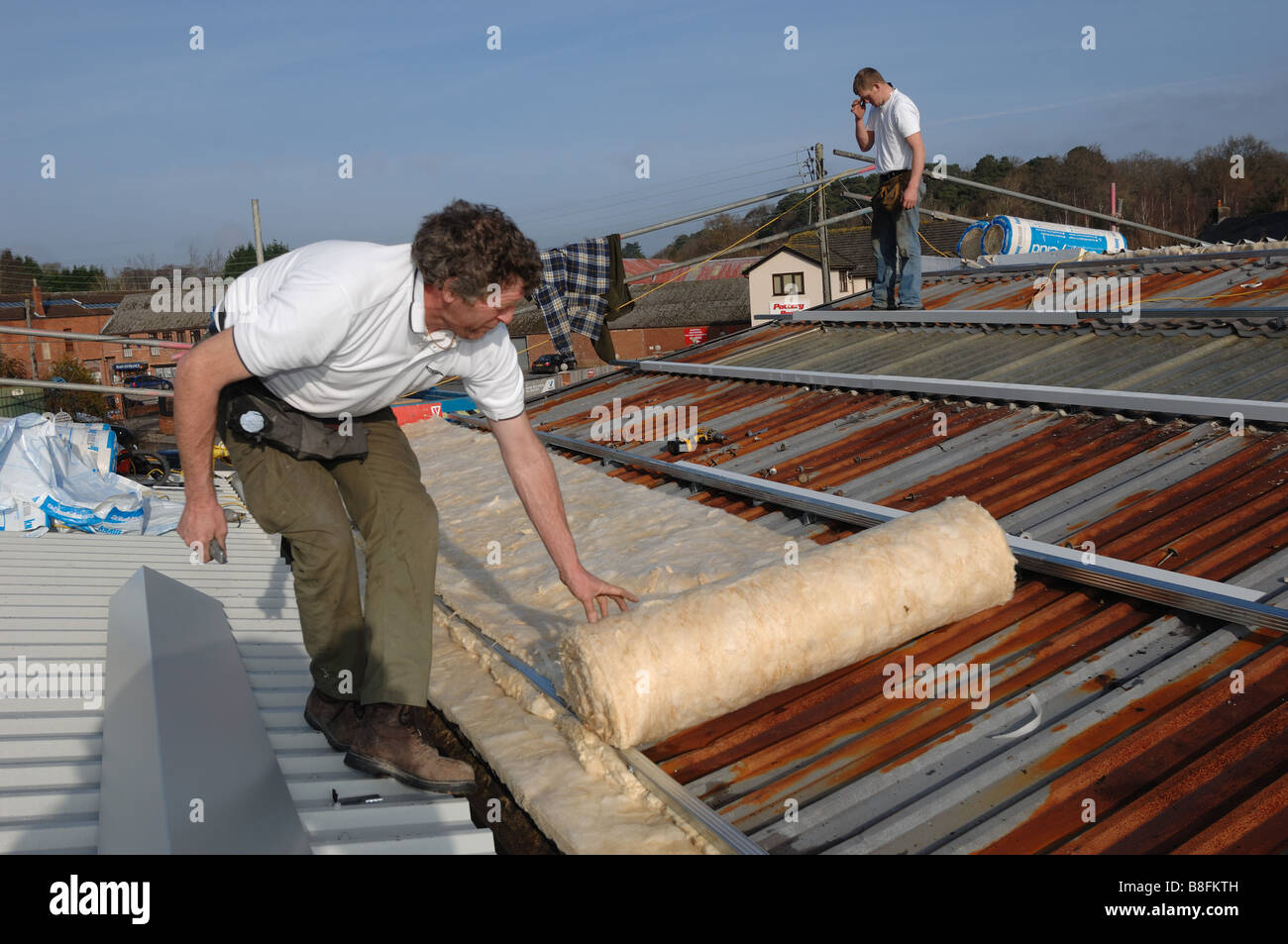 Les entrepreneurs isolation supplémentaire sur le toit d'une unité industrielle à Bovey Tracey Devon Banque D'Images