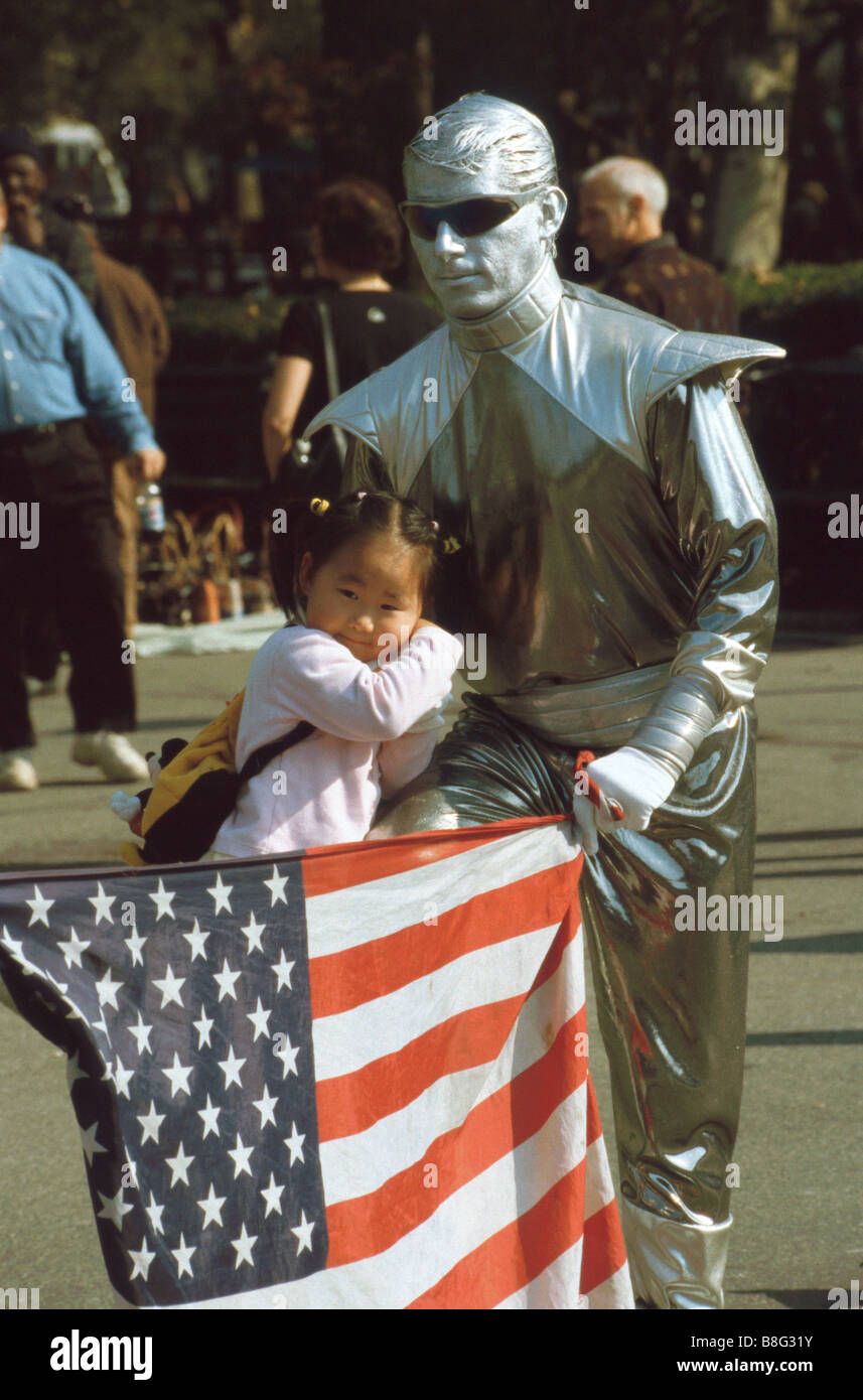 Artiste de rue/artiste mime holding American flag/stars and stripes à New York avec enfant/membre de foule, New York, États-Unis Banque D'Images