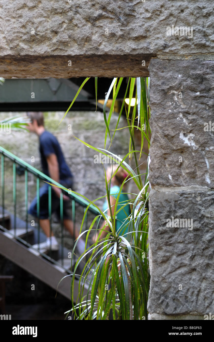 Deux enfants ascending stairs avec mur de pierre ciselée à la main en premier plan, The Rocks, Sydney, Australie Banque D'Images