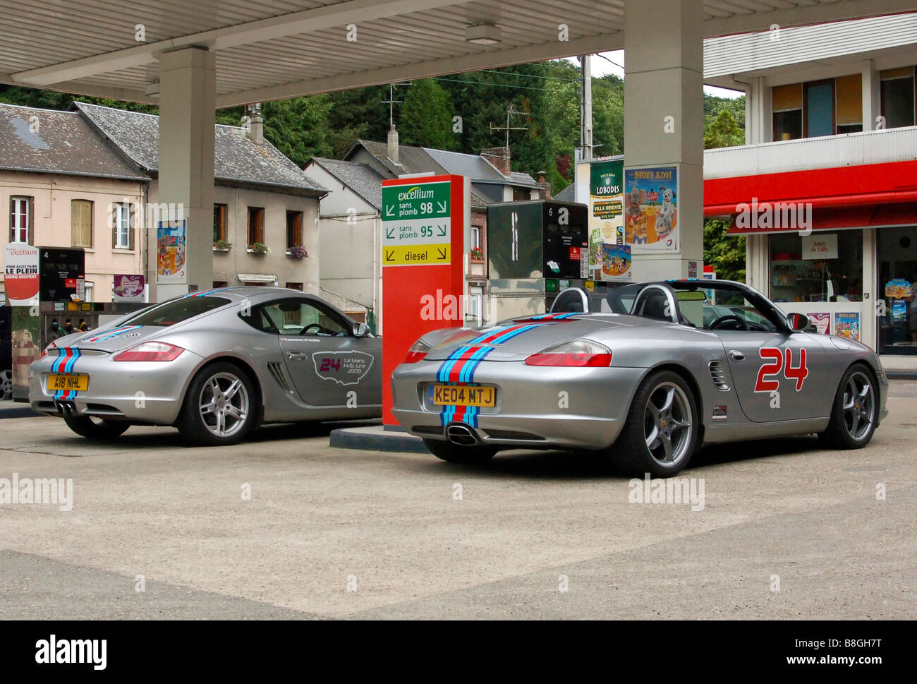 Porsche Cayman (987) et Boxster S (550) Spyder avec Martini racing stripes dans un village français station d'essence. Banque D'Images