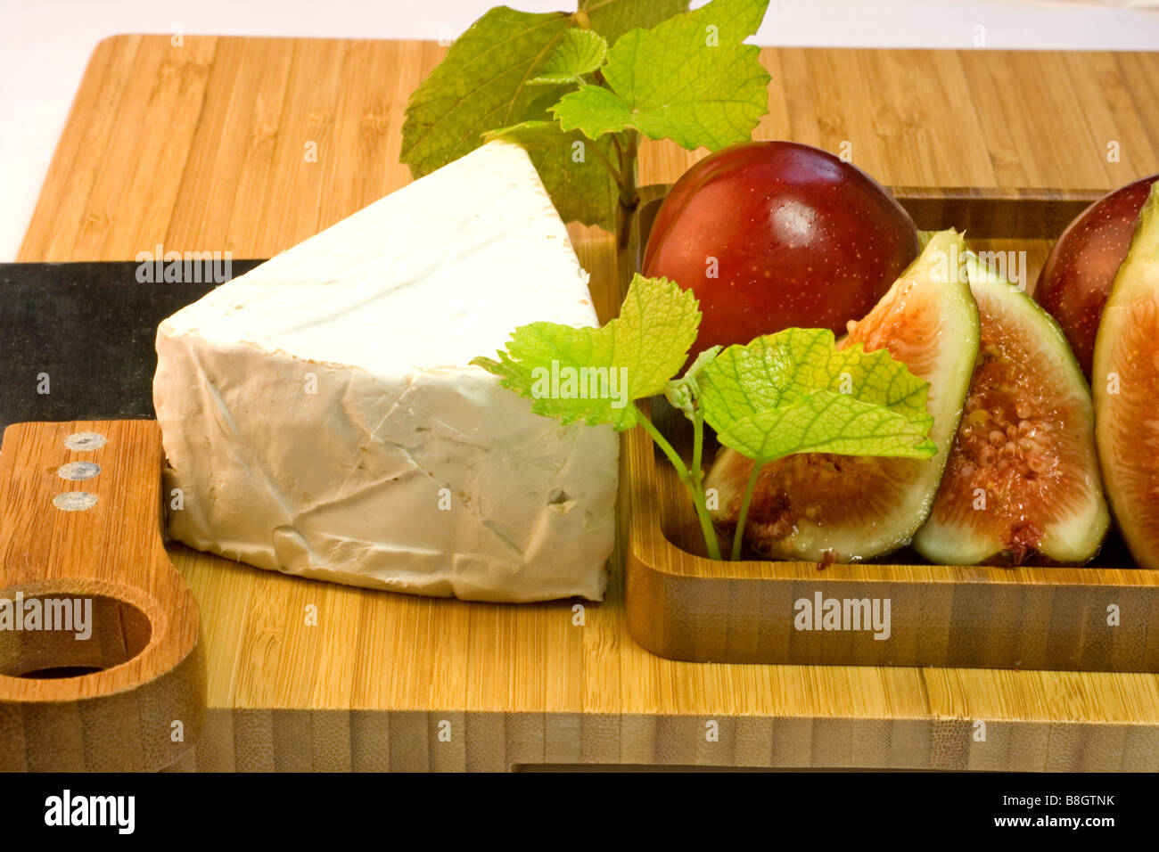 Le fromage et les fruits sur un plateau de fromages Banque D'Images