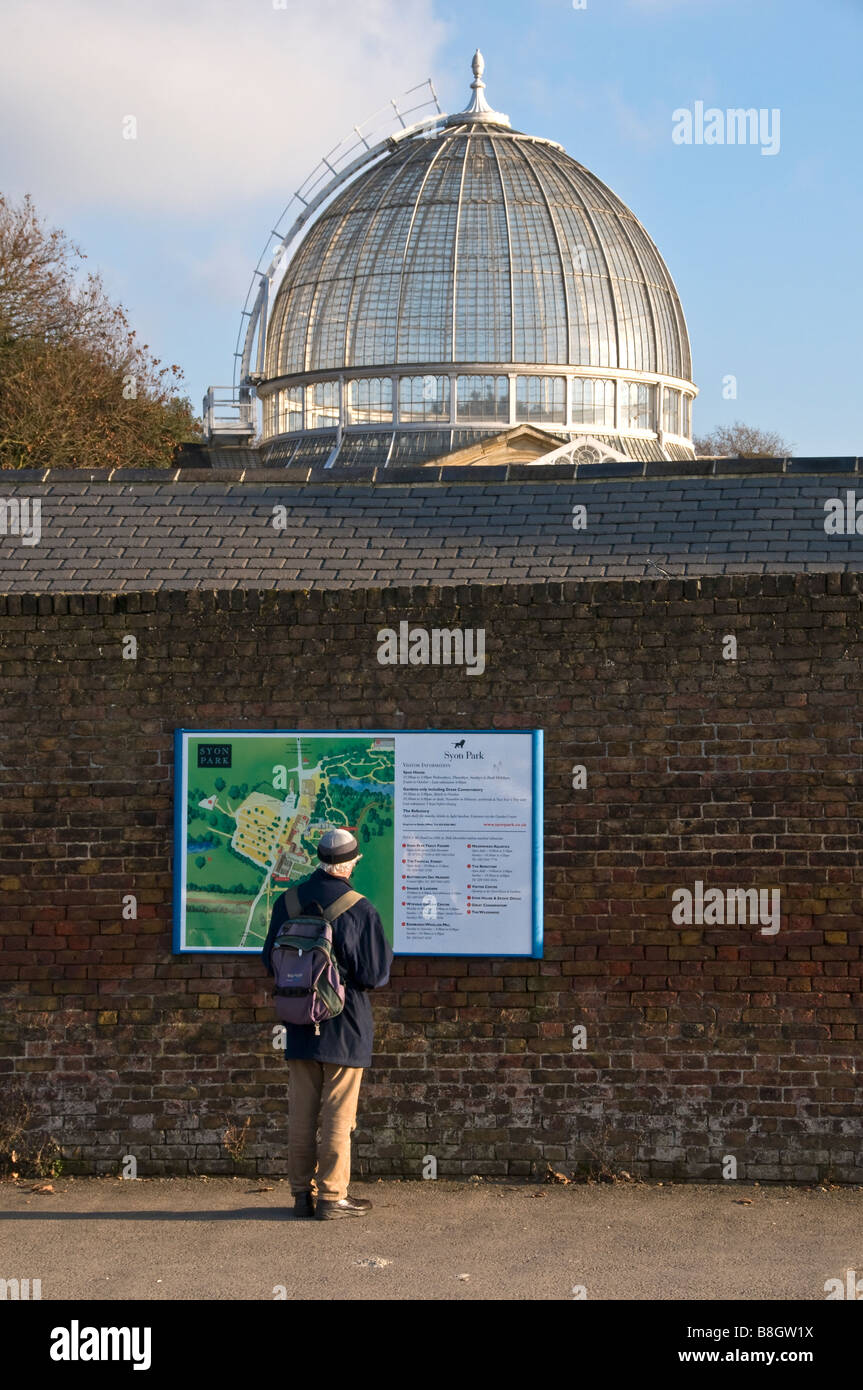 Un touriste se tient en dehors de Syon House Park reading a map, Syon House Park, à l'ouest de Londres, Brentford, Middlesex, Angleterre Banque D'Images