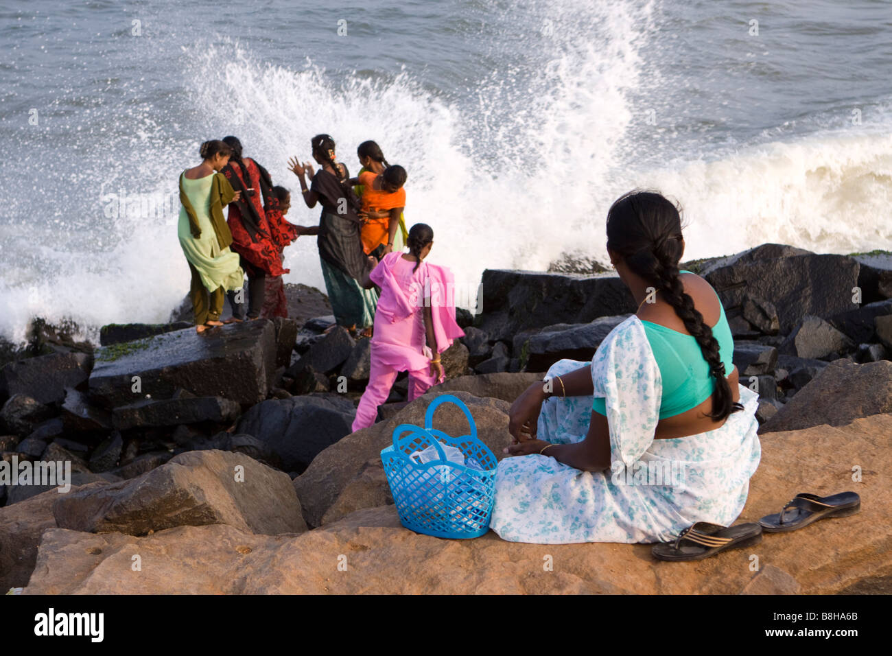 Inde Pondichéry Indian women touristes détente sur front de mer à la fin de l'après-midi dans les embruns Banque D'Images