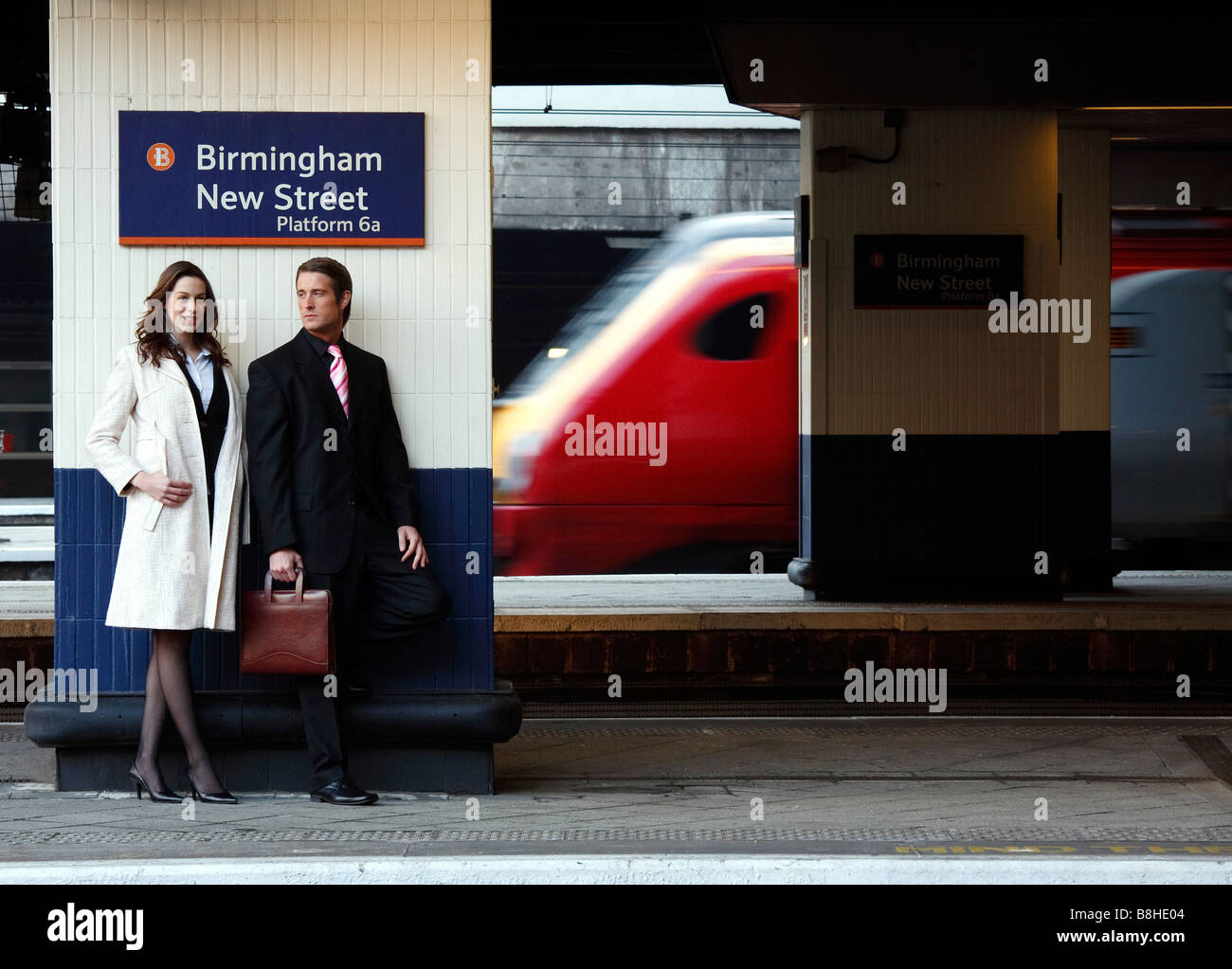 Femme d'affaires et sur une plate-forme de la gare avec un train en direction de passé Banque D'Images