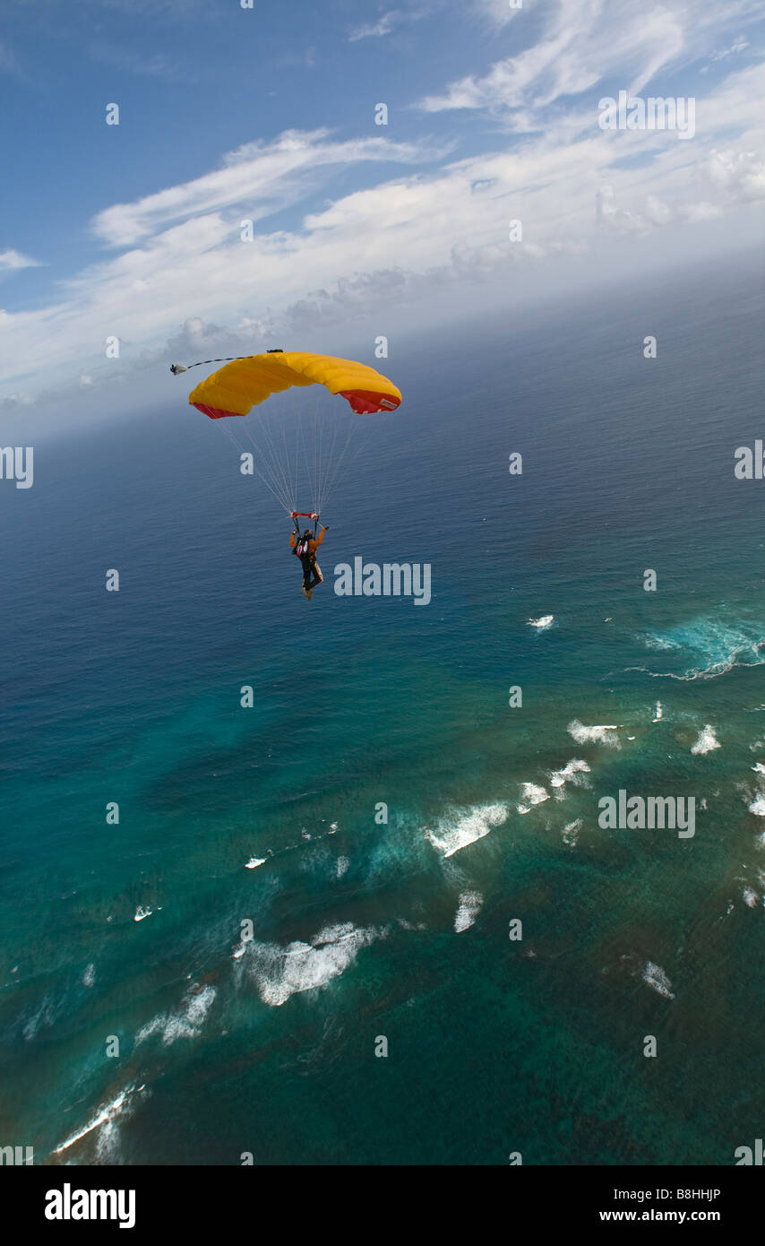 Parachutiste sous l'auvent est volant le long de la ligne de coût à partir d'Hawaï se prépare à faire une plage de l'atterrissage. Banque D'Images