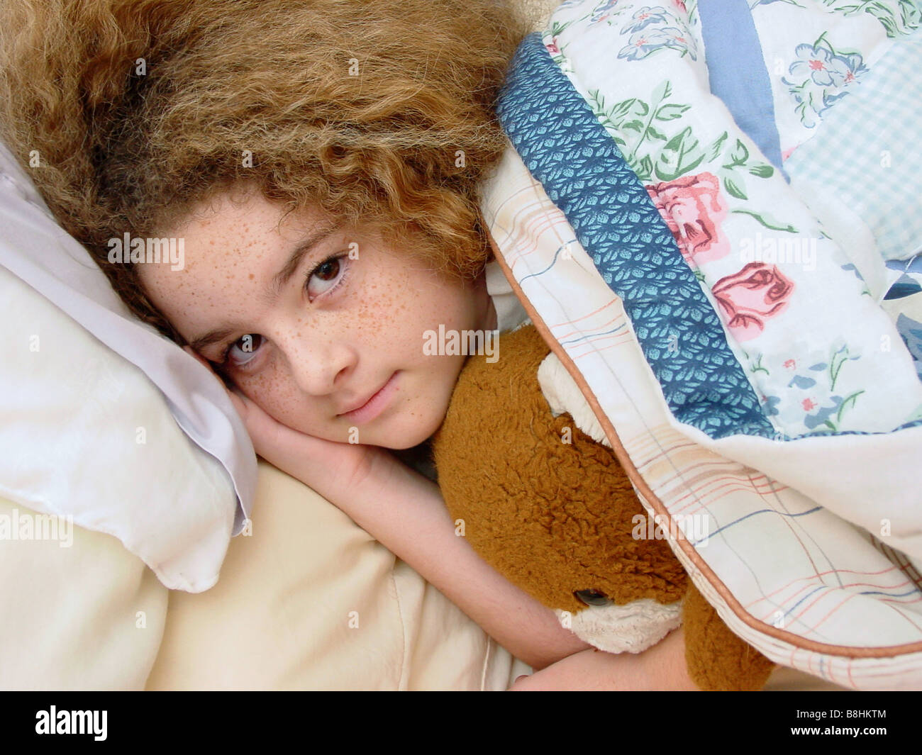 Adorable petite fille nichée dans et prêt pour le lit Banque D'Images