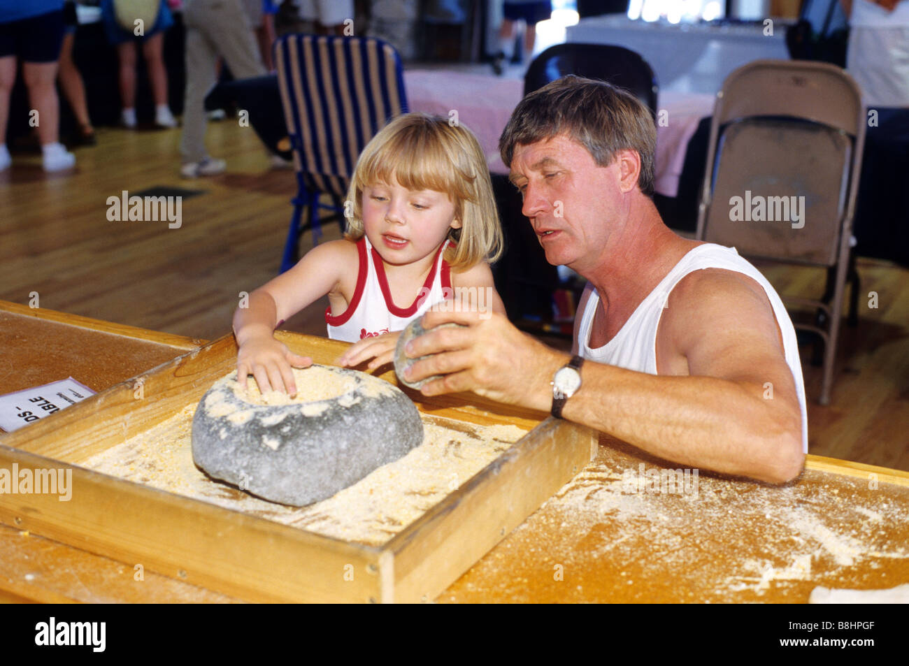 Père et fille à l'aide d'un mortier et pilon dans le musée des Indiens d'Amérique du Nord au Crazy Horse Memorial dans le Dakota du Sud Banque D'Images