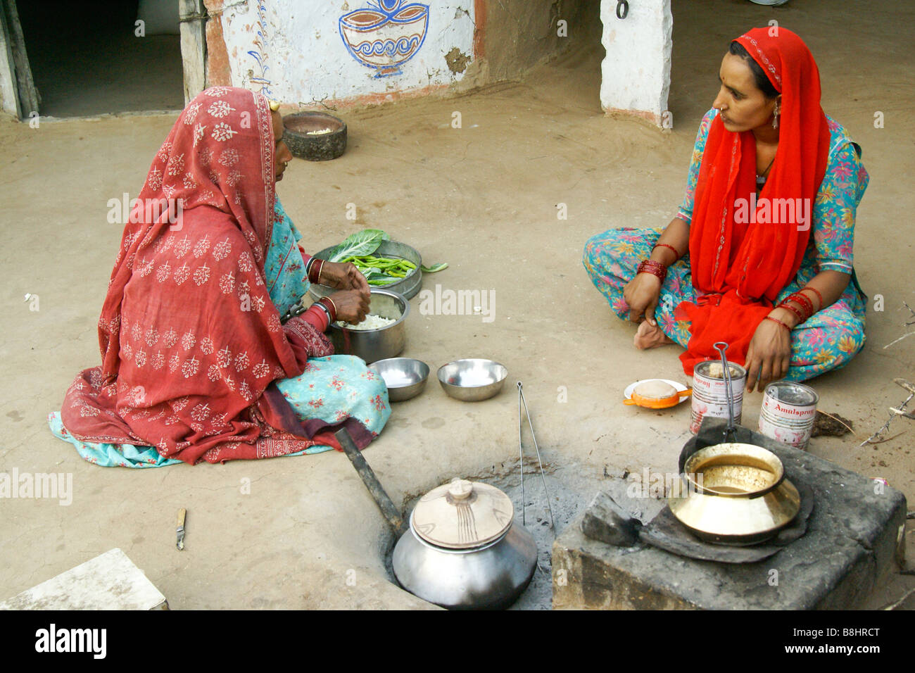 La préparation de repas à l'extérieur des femmes Bishnoi home, Rajasthan, Inde Banque D'Images