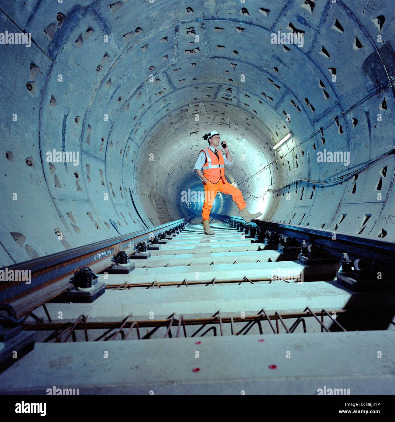 Engineer inspecting trackwork nouvellement posées dans un Jubilee Line Extension tunnel sur le réseau de métro de Londres. Banque D'Images