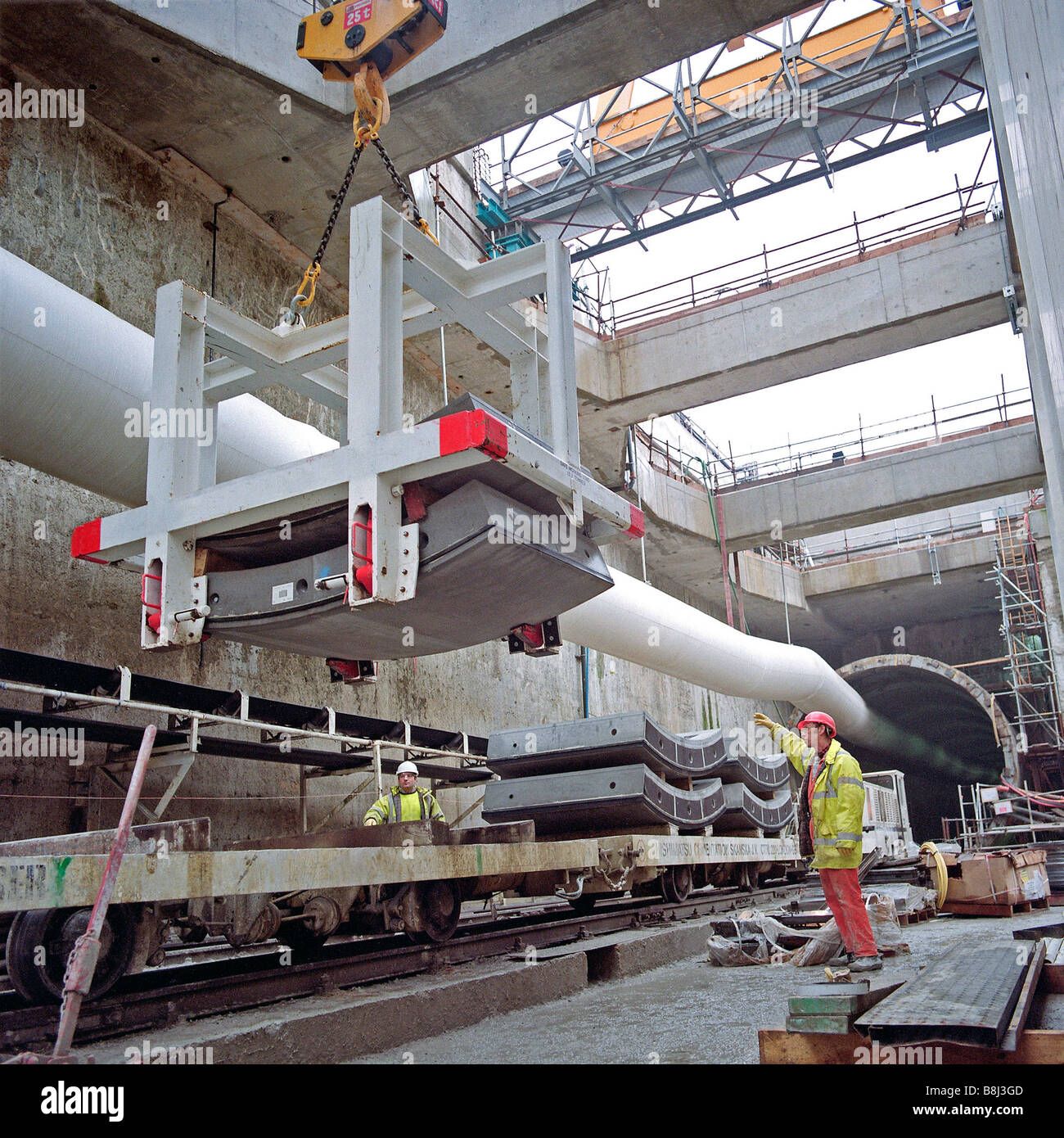 Revêtement de béton chargement sur des segments à l'aide du transparent trains travaux grue à portique à Stratford fort sur le Channel Tunnel Rail Link. Banque D'Images