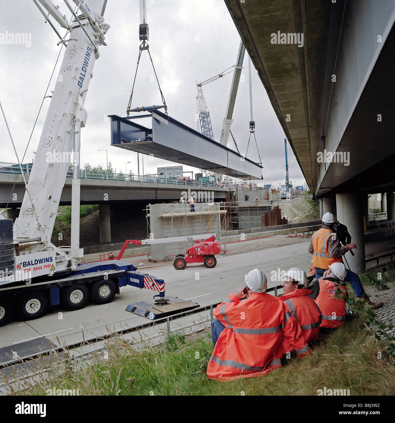 Levage tandem de poutres de pont en acier à l'aide de 1000 tonnes grues mobiles sur autoroute M20 à Coquelles pour le Channel Tunnel Rail Lin Banque D'Images