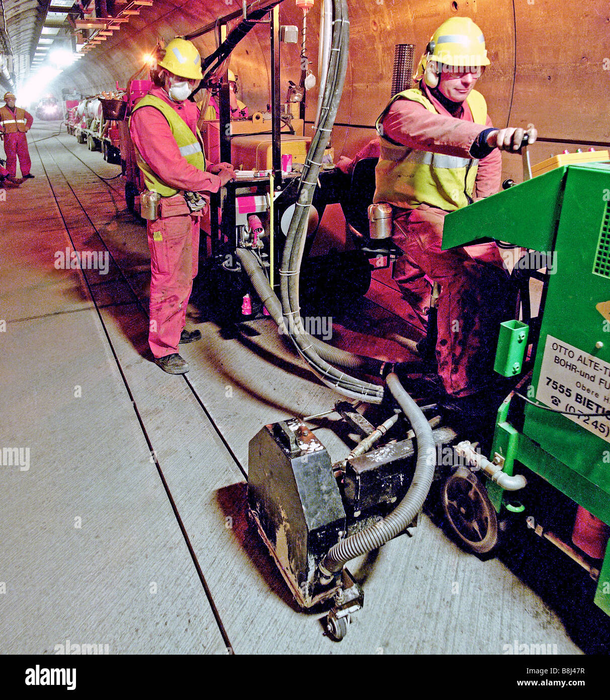 Les rainures de coupe dans un sol en béton du Tunnel sous la Manche tunnel de service avant d'installer les fils d'orientation pour les véhicules STTS. Banque D'Images