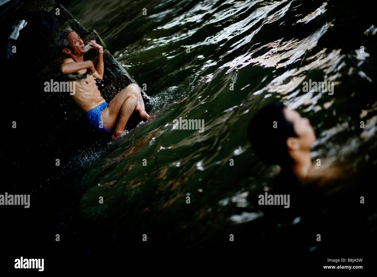Un homme lui-même après la baignade en gommages la rivière des Perles de Guangzhou, Chine. Banque D'Images