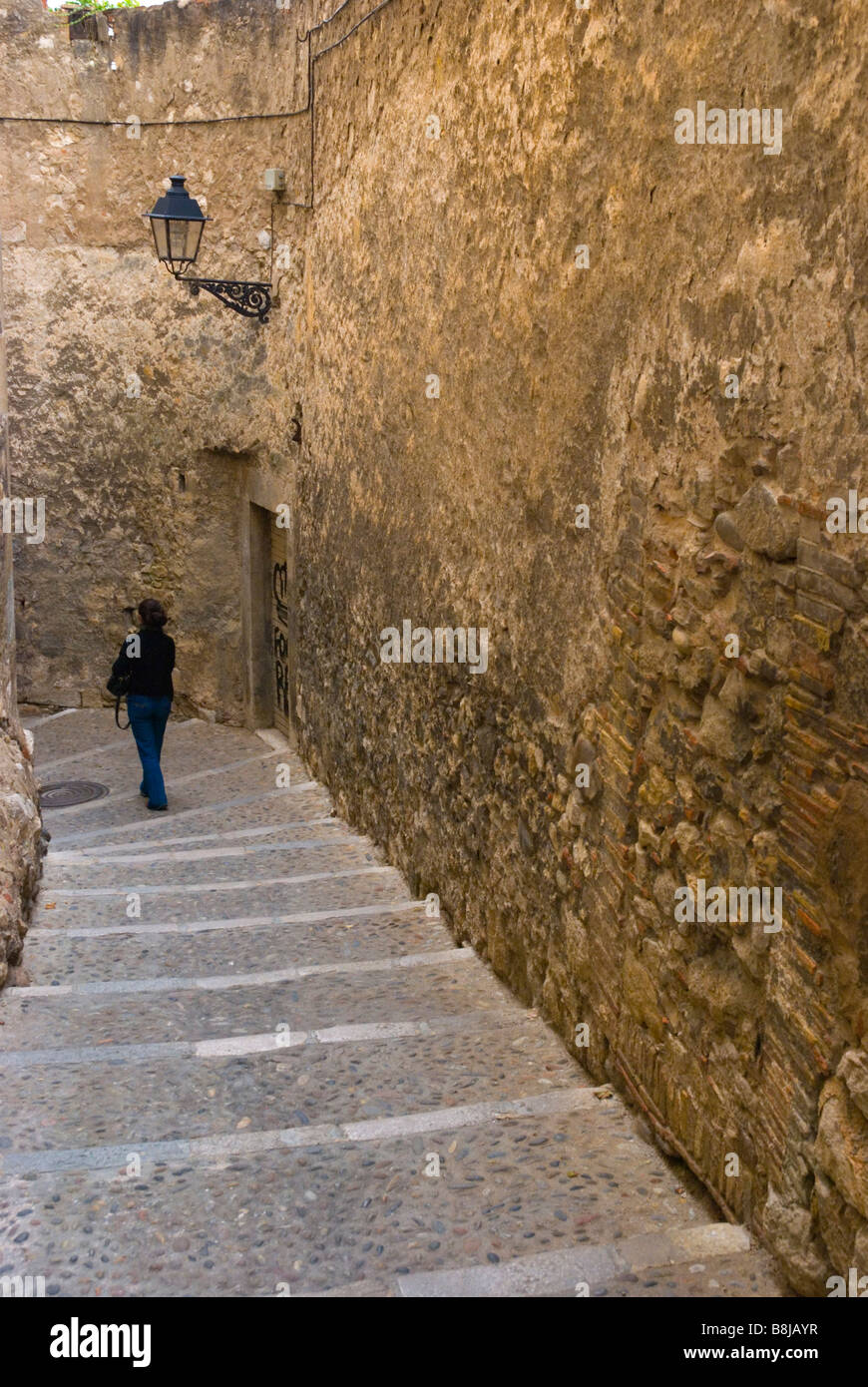 Femme de descendre les escaliers dans la vieille ville de Barri Vell Gérone Espagne Europe Banque D'Images