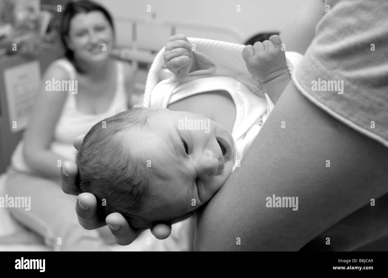 La Naissance D Un Bebe Garcon Est Tenu Par Son Pere Pendant Que La Mere Sourit Du Lit Dans La Maternite De L Hopital Photo Stock Alamy