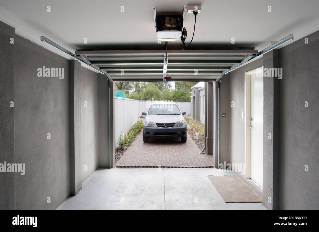 Une voiture dans un garage avec une porte de garage automatique Photo Stock  - Alamy