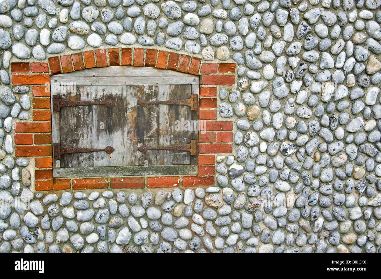 Flint Norfolk avec mur de brique et porte ancienne entourent Banque D'Images