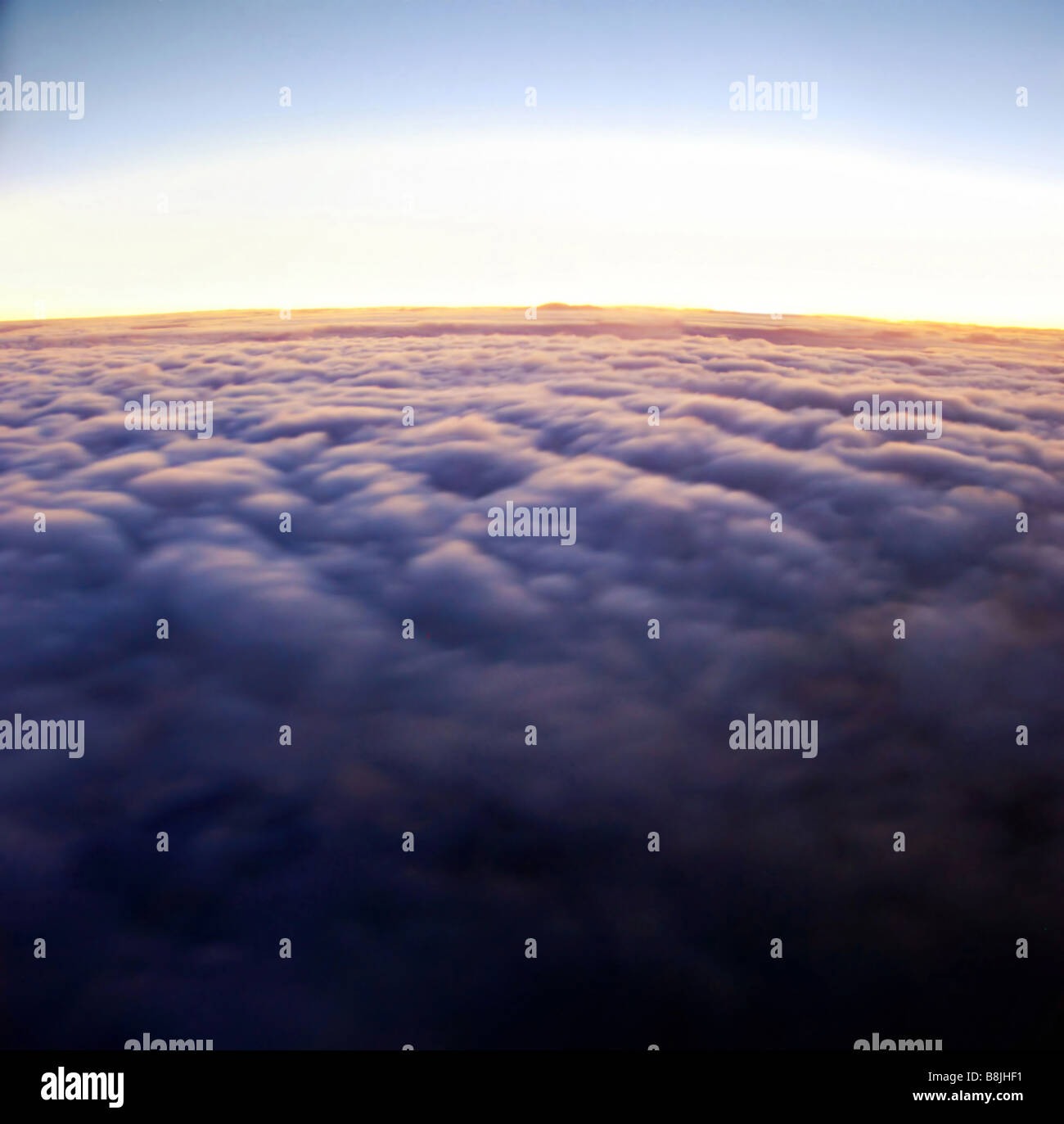 Soleil début de s'élever au-dessus de la couche de nuages Banque D'Images