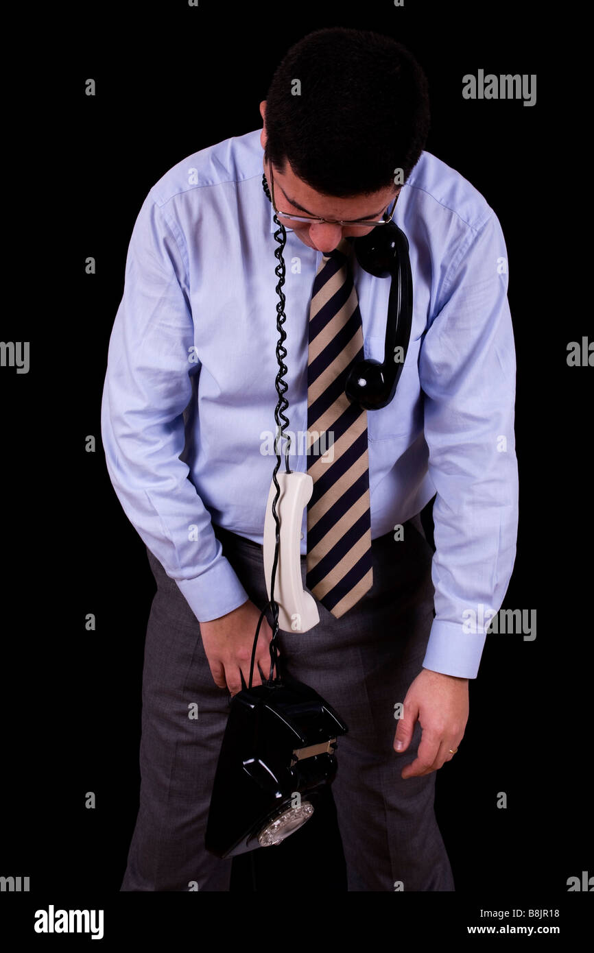 Businessman étrangler avec son téléphone isolated on black Banque D'Images