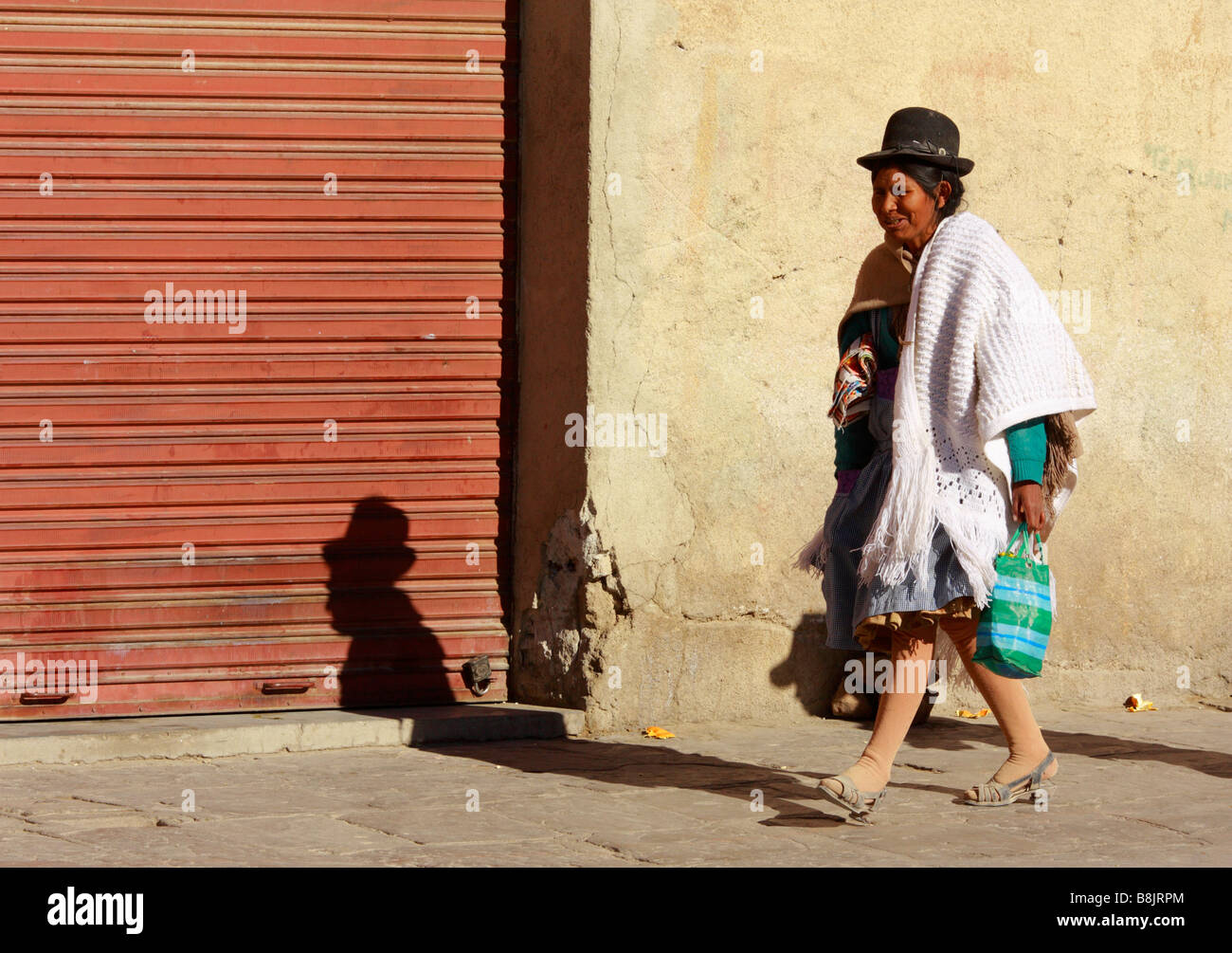 Une femme vêtue d'un chapeau traditionnel marche sur la rue à Uyuni en Bolivie Banque D'Images
