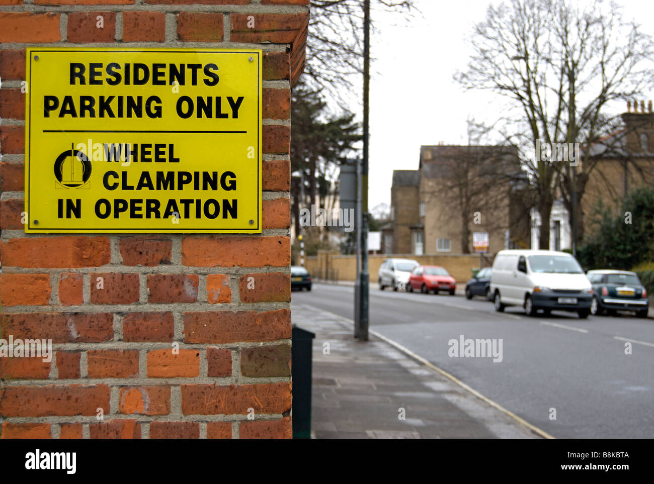 Parking résidents noir et jaune, seul signe avec avertissement de serrage de roue à l'opération, à Twickenham, Middlesex en Angleterre Banque D'Images