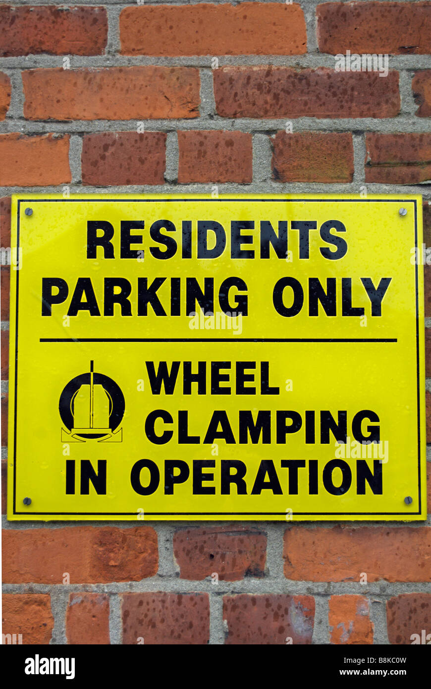 Parking résidents noir et jaune, seul signe avec avertissement de serrage de roue à l'opération, à Twickenham, Middlesex en Angleterre Banque D'Images